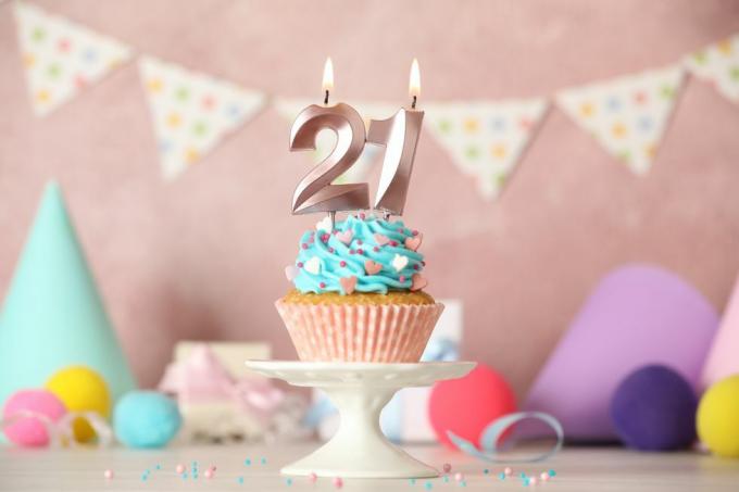 Cupcake zum 21. Geburtstag mit Zahlenkerzen auf weißem Tisch