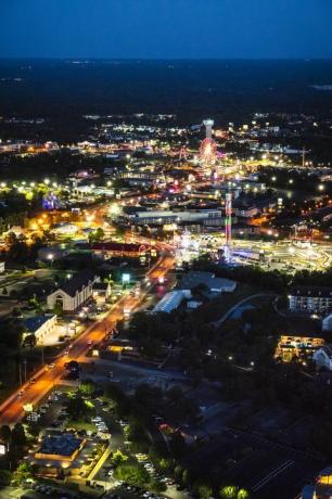 nächtliche luftaufnahme des hwy 76, branson missouri mit neonbeleuchtetem riesenrad, turm und mehr