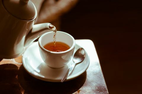 Teetasse auf Untertasse, Tee wird eingegossen,