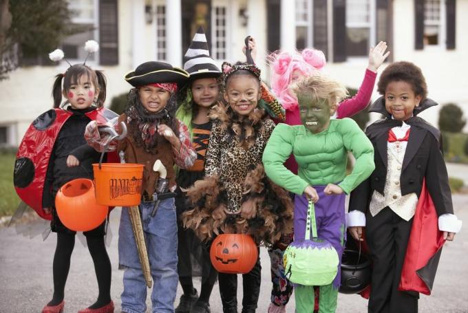 Vielfältige Gruppe von Kindern in Herbstkostümen und Halloweenkostümen