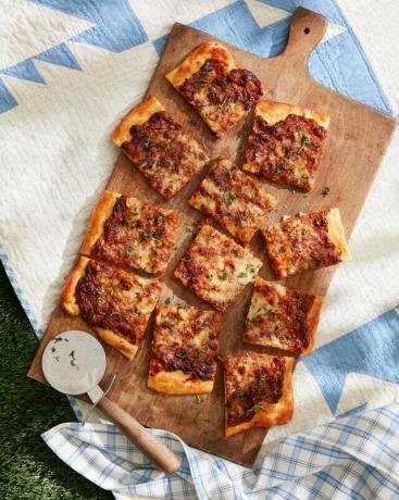 Französisches Zwiebelfladenbrot auf einem Holzschneidebrett auf einer Picknickdecke