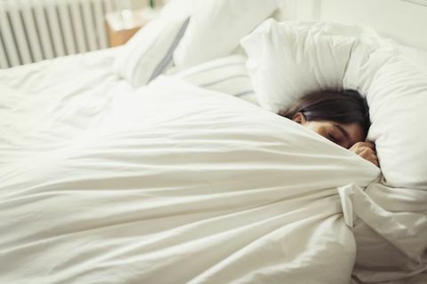 müde junge frau, die im bett schläft