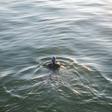 Großbritannien, Kent, Herne Bay, Freiwasserschwimmerin, die hart im Meer trainiert