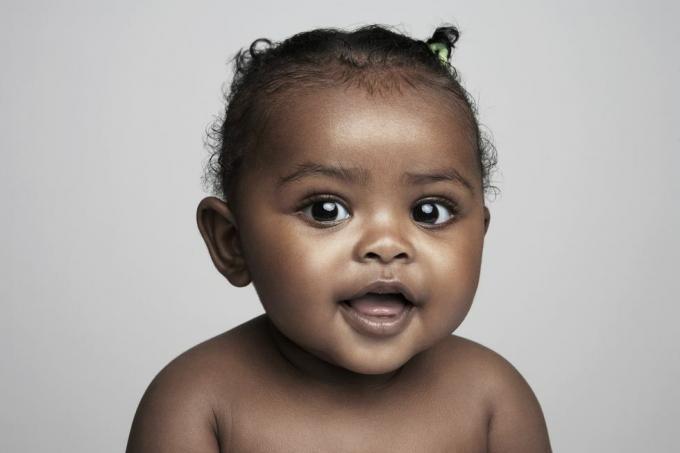 Babymädchen, das 6 bis 9 Monate alt ist, lächelnd, Porträt