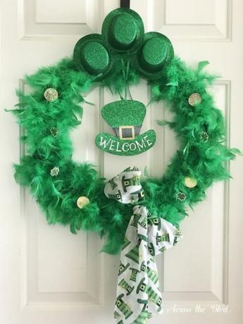 St. Patrick's Kranz aus grünen Federn mit drei kleinen grünen Zylinderhüten oben und kleinen Goldmünzen darüber und einem Schal, der unten in einer Schleife gebunden ist