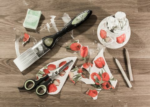 Decoupage-Werkzeuge auf Holztisch, einschließlich Pinsel, Schere, Bleistift, Schwamm und ausgeschnittenem Papier