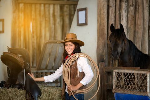 Frauen im Cowboykostüm mit Pferd im Hintergrund