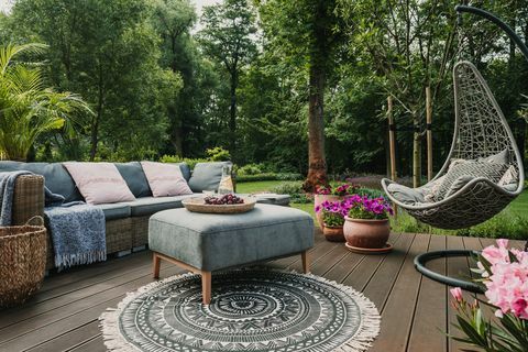 Gartenterrasse mit skandinavischem Korbsofa und Couchtisch