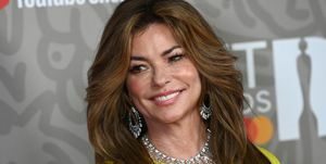 Shania Twain in gelbem Kleid und Diamanthalskette