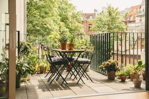 Bistrostühle und Tisch auf Balkon mit Blick in den Hof