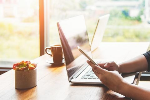 Frau mit Smartphone und Laptop