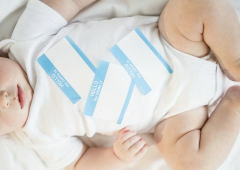 Baby mit Namensaufklebern auf seinem Kasten