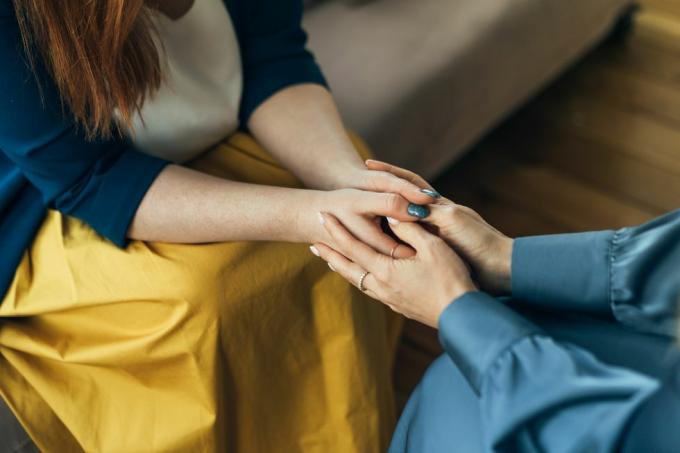 Zwei Frauen sitzen in Sesseln und unterhalten sich. Eine Psychologin spricht mit einer geduldigen Trainerin, die einer lächelnden Therapeutin die Hände gibt. Gestik einer Frau, die im Coworking-Büro spricht