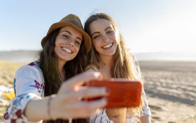 Zwei beste Freunde machen Selfie mit dem Smartphone am Strand