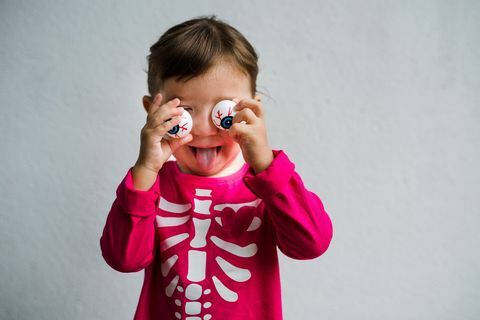 kleines Mädchen gekleidet in ein Skeletthemd mit lustiger Brille