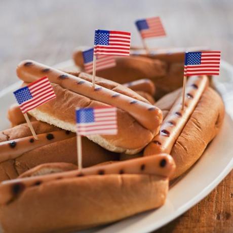 kleine amerikanische Flaggen in gegrillten Hot Dogs auf Brötchen