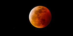 ein Blutmond oder Vollmond mit einem rötlichen Schatten aufgrund einer totalen Mondfinsternis am Nachthimmel