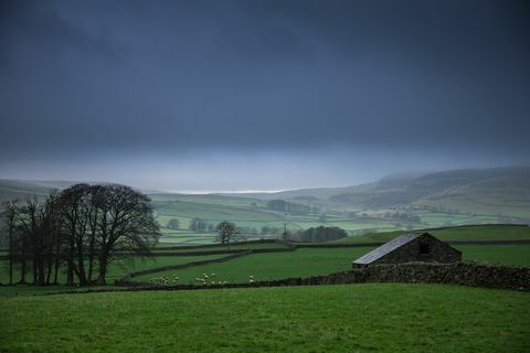 Bauernhof unter dunkelgrauen Wolken