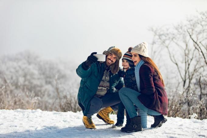 Familie macht Selfie an einem Wintertag im verschneiten Wald