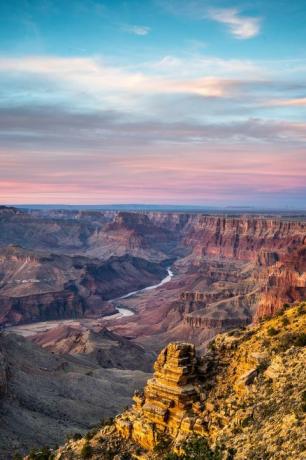 Malerischer Blick auf den Grand Canyon National Park mit Sonnenuntergang im Hintergrund und Fluss, der durch ihn fließt