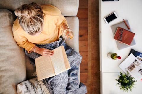 Overhead Shot Blick auf Frau zu Hause liegend auf Lesebuch und Wein trinken