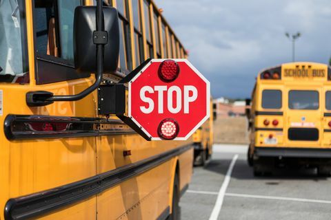 Schulbusfahrer, der vor der Fahrt mehrere Aspekte des Busses überprüft