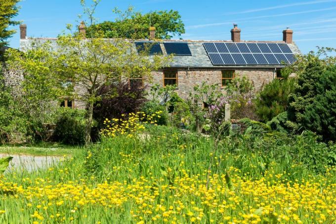 Sonnenkollektoren und Dachwärmetauscher für Warmwasser auf einem historischen Anwesen in Cornwall, Südengland, Großbritannien