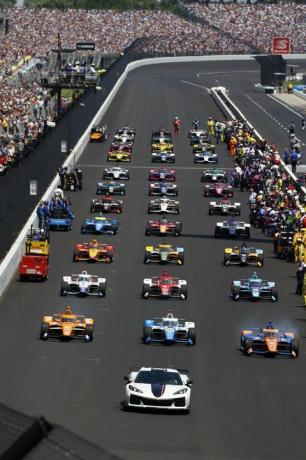 Indianapolis 500 mit Frontansicht von Autos auf der Rennstrecke aufgereiht und Menschen auf Tribünen