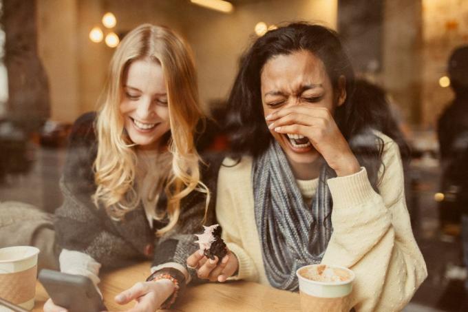 Freundinnen mit Smartphone im Coffeeshop