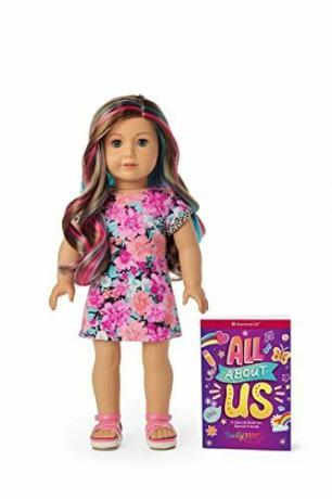 Puppe 101 mit grauen Augen und gewelltem karamellfarbenem Haar mit rosa und blauen Strähnchen