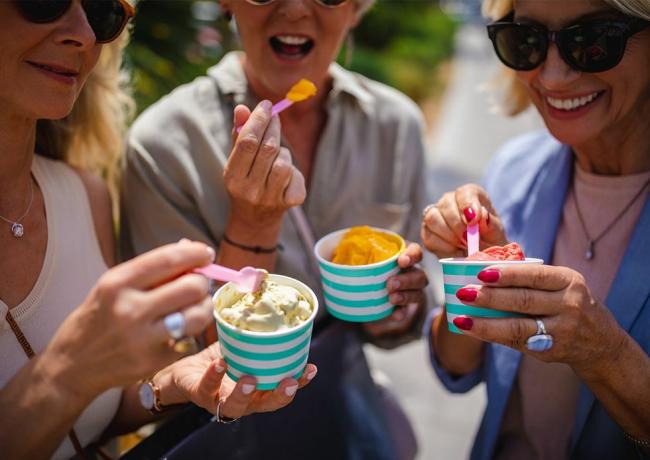 Freunde essen beim Eiscreme-Festival in einer Pause vom Einkaufen