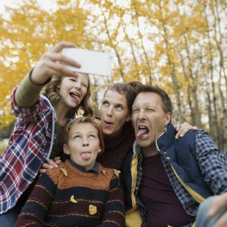 Dumme Familie macht Selfie und macht Gesichter im Herbstpark