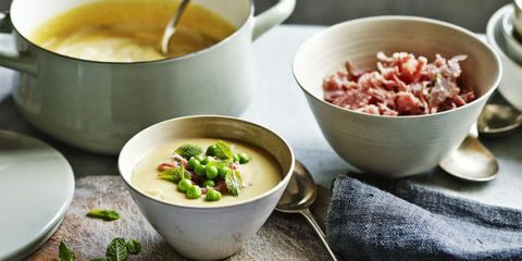 Erbsen-Schinken-Suppe in Schale mit frischer Minze neben Schale mit Schinken