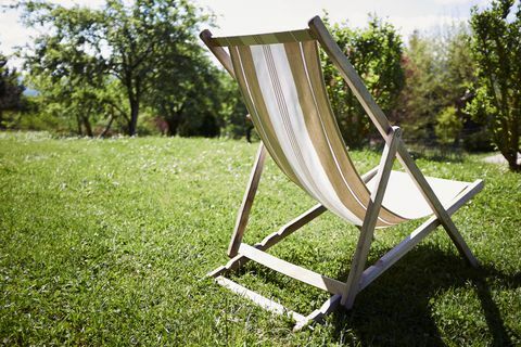 Leerer deckchair im sonnenbeschienen Garten